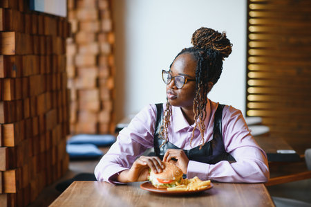 african american woman with vegan meatless burger meal.