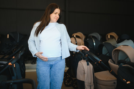 Young pregnant woman in shop of children goods. The choice for a baby stroller.