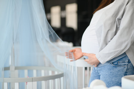 Happy pregnant woman choosing a baby crib in the store.の写真素材