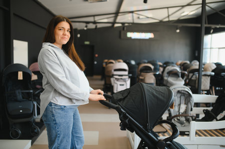 Young pregnant woman in shop of children goods. The choice for a baby stroller.