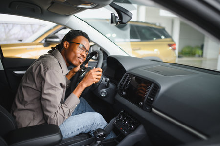 Young man is choosing a new vehicle in car dealership.