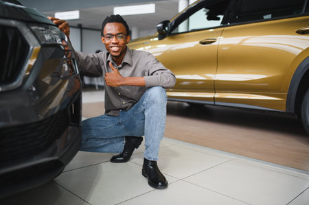Young African American man is choosing a new vehicle in car dealership.の写真素材