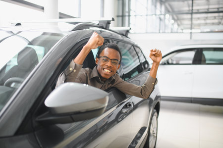 Young man is choosing a new vehicle in car dealership.