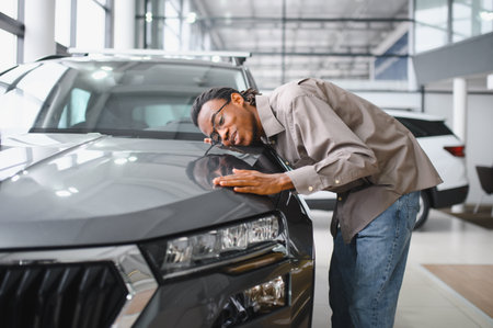 Young African American man is choosing a new vehicle in car dealership.の写真素材