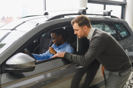 A consultant helps a customer choose a new car.の写真素材