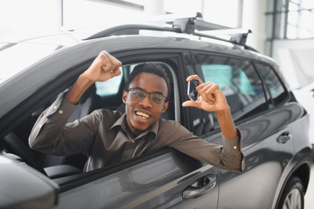 Young African American man is choosing a new vehicle in car dealership.の写真素材