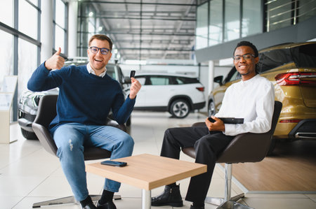 A man holds the keys to a new car. A contract has been signed with a dealer to purchase the car.の写真素材