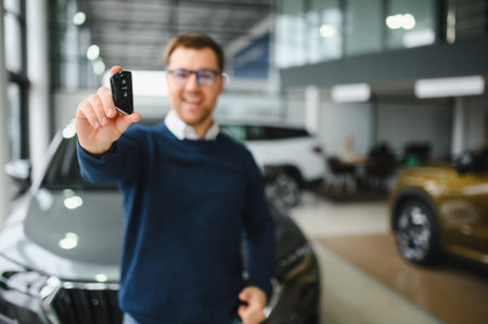 Young man is choosing a new vehicle in car dealership.