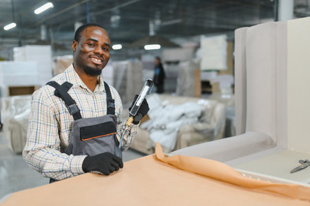 Skilled craftsman upholstering a sofa in a furniture factory, demonstrating expertise and craftsmanship in furniture productionの写真素材