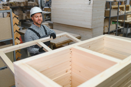 Worker in a furniture factory assembling a wooden frame, highlighting craftsmanship and precision in...