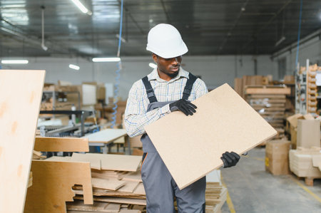 Skilled carpenter handling wood panel, demonstrating craftsmanship and precision in furniture...