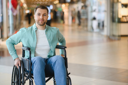 Man in a wheelchair navigating a busy shopping center, highlighting mobility challenges and...