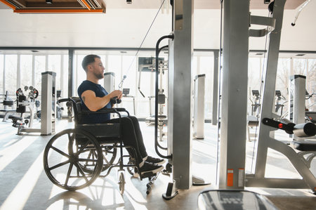 Patient using specialized equipment for rehabilitation and physical therapy in a modern gym, promoting accessible fitness and recoveryの写真素材