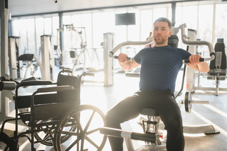 Person with disability exercising using a chest press machine inside a modern gym for rehabilitation, promoting inclusivity and active lifestyleの写真素材