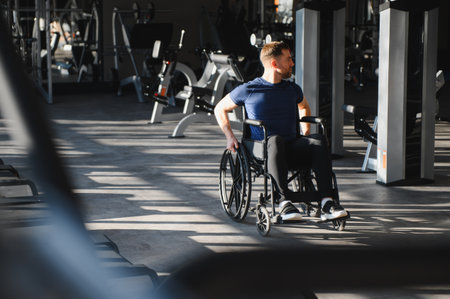 Man with disability exercise and training in a wheelchair at the gym for rehabilitation and physical therapyの写真素材