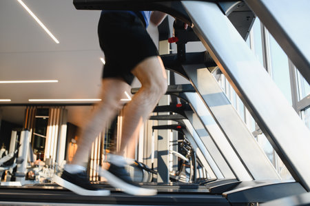 Patient running on treadmill, exercising legs in gym during rehabilitation treatment, promoting...