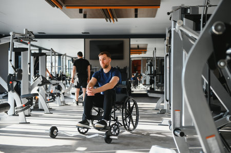 Young man with disability exercising in a gym, demonstrating inclusion and promoting a healthy lifestyle through adapted physical activityの写真素材