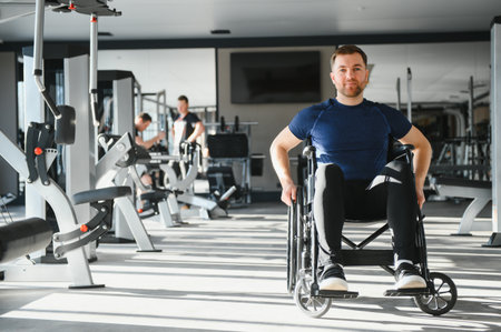 Man with disability exercise in wheelchair at modern gym, showing determination and strength during...