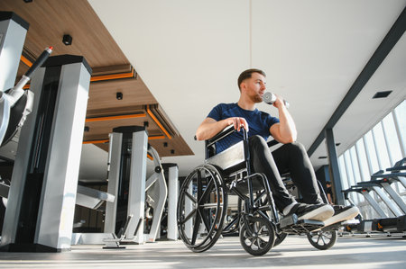 Man with disability exercising with weights in modern gym, demonstrating inclusion and...