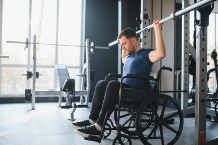 Person with disability exercising with barbell in gym, demonstrating resilience and strength during...