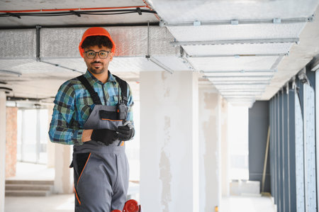 Arab engineer installing ventilation system on construction site.