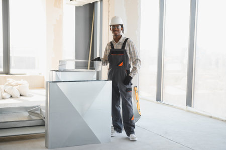 African american construction worker installing a ventilation system in a building under...