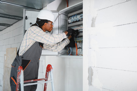 Electrician installing electrical panel in new building, ensuring safe and efficient power...