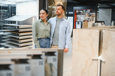 Couple selecting ceramic tiles and sanitary ware in a modern hardware store, enjoying the process of enhancing their home's interior designの写真素材