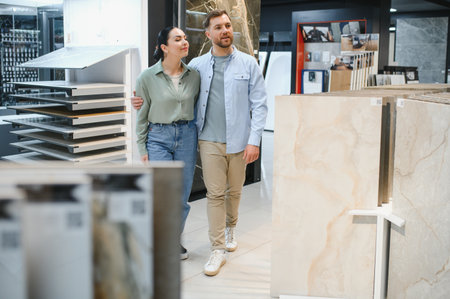 Young couple walking in a hardware store choosing ceramic tiles for their apartment renovationの写真素材