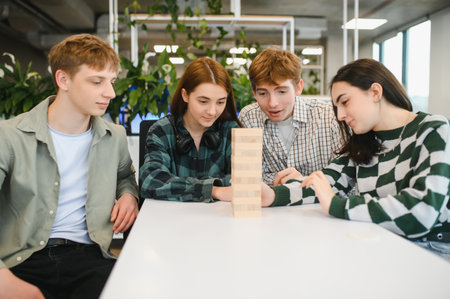 Four young colleagues are enjoying a game break, carefully strategizing their moves in a captivating...