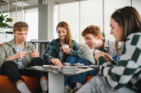 Four cheerful colleagues are enjoying a break from work, playing a board game together in a casual office spaceの写真素材