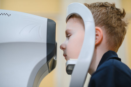 Boy using a modern autorefractor for vision testing in a medical facility, ensuring accurate...