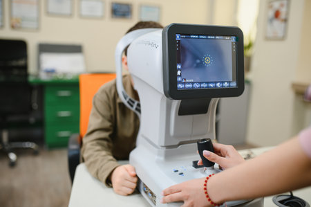 Ophthalmologist uses an autorefractor to examine a child's vision in a modern eye clinic, providing...