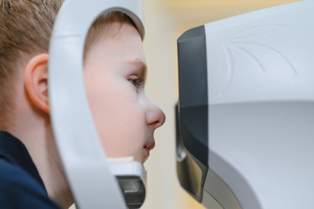 Boy having his eyesight checked by an ophthalmologist using a modern autorefractor in a vision...