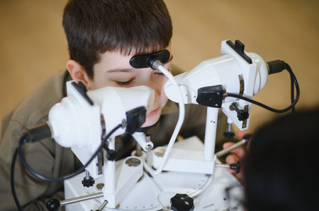 Ophthalmologist examining a young boy's eyesight using advanced medical equipment in a modern clinic...