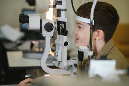 Ophthalmologist examining eyesight of a young boy using a slit lamp biomicroscope in a modern...