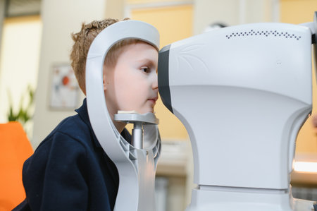 Child patient engaging with a modern autorefractor during an eye examination in an ophthalmology...