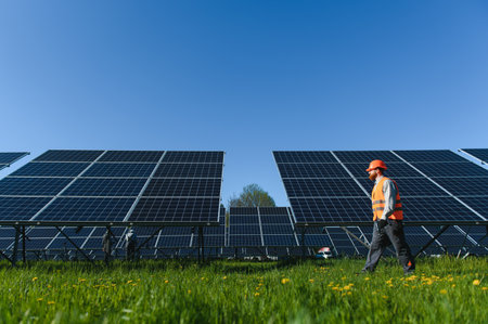 Engineer inspecting a solar panel farm, ensuring efficient green energy generation and sustainable power solutionsの写真素材