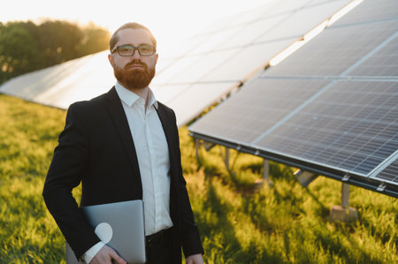 Investor assessing the performance of photovoltaic panels at a solar energy power plant, focusing on...