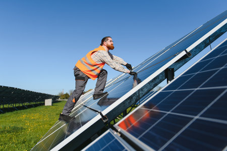 Engineer working diligently on the installation of photovoltaic panels at a vast solar power plant,...