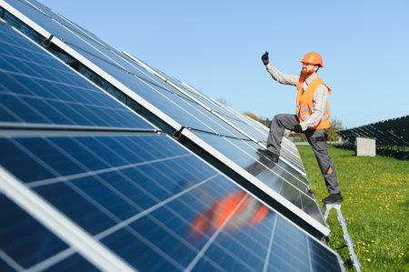 Engineer inspecting photovoltaic panels in a large solar power plant, gesturing thumbs up to confirm...