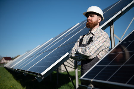 Engineer with arms crossed monitoring photovoltaic panels in a solar power plant, ensuring efficient...
