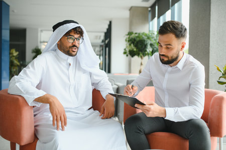 International operations manager taking notes while discussing contract with Saudi business partner...