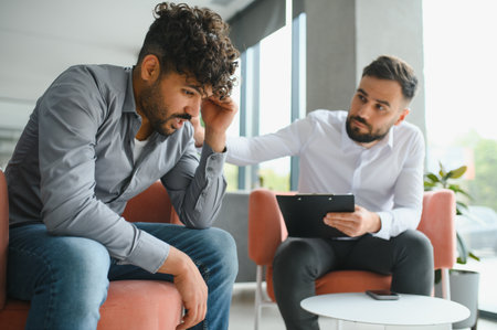 Psychologist supporting upset patient during therapy session, helping him cope with mental health...