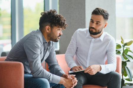 Psychologist provides support and guidance to an upset Arab man during a therapy session, addressing...