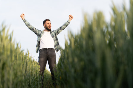 Farmer expressing joy and satisfaction amidst a thriving wheat field, celebrating a bountiful...