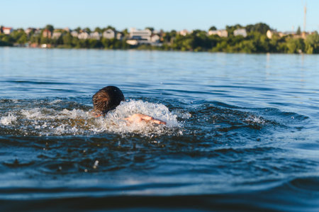 Man swimming in lake water, moving farther from the shore, struggling against the waves, fighting...