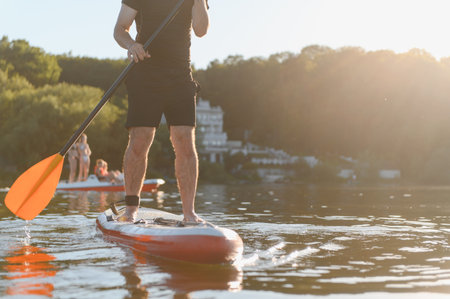 Sportsman paddling on a sup board on a lake during a sunny summer afternoon, enjoying some active...