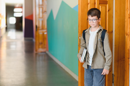 Young pupil walking into a classroom, carrying books and a backpack, eagerly preparing for an exciting day of learning and discoveryの写真素材