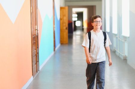 Boy with backpack walking in school hallway during break time, education and back to school conceptの写真素材